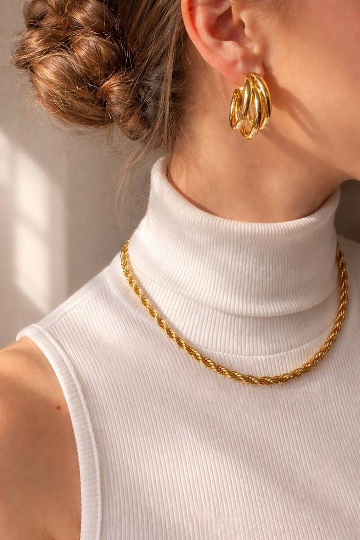 Gold hoop earrings worn beside swept-back hair