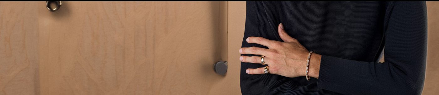 Hands wearing diamond rings and a bracelet